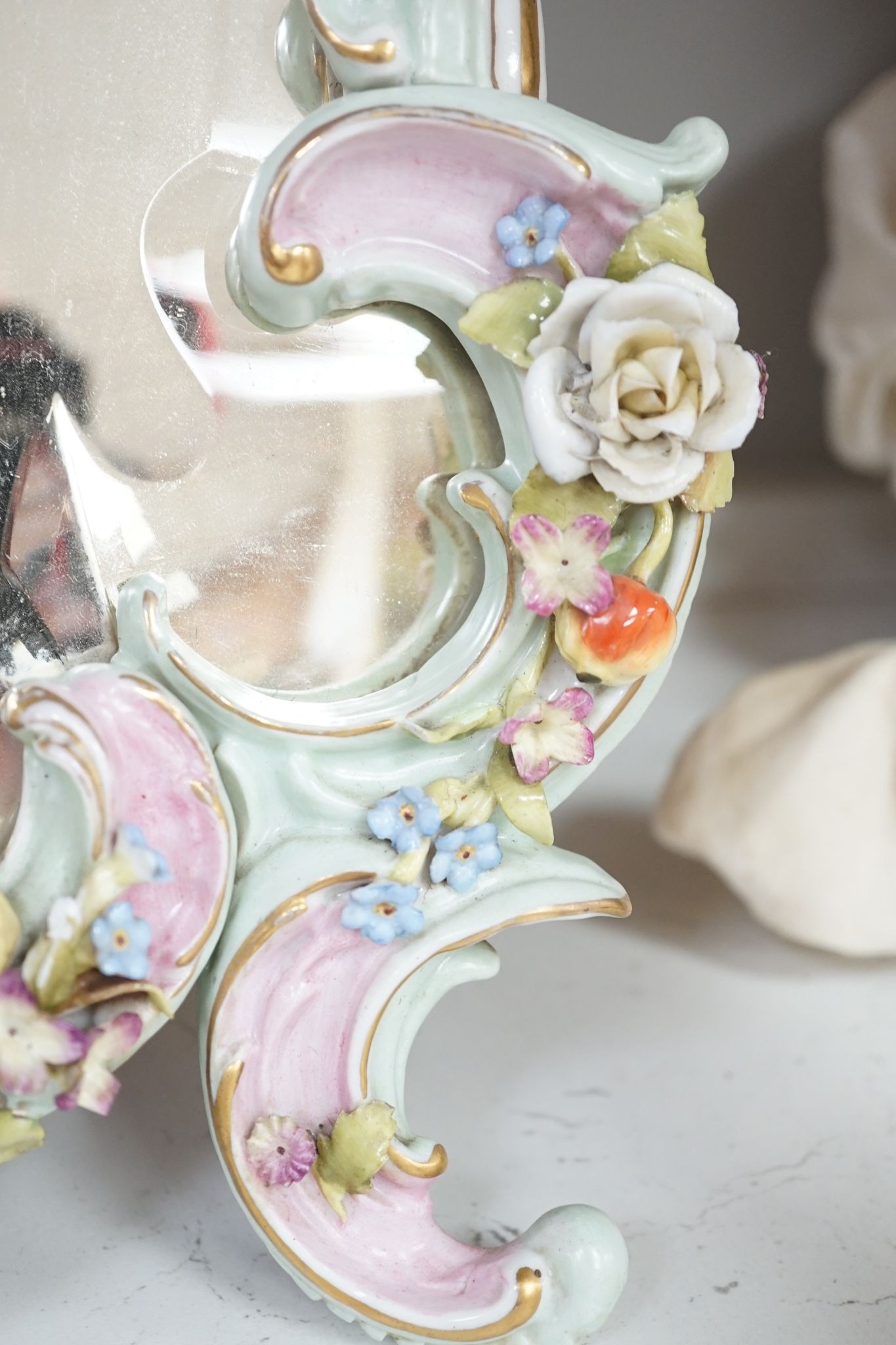 Two German porcelain easel mirrors and a Belleek easel mirror, tallest 43cm
